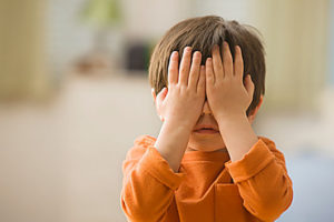 Mixed race boy covering his eyes